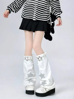 White Jirai Kei mid-calf leg warmers with silver star prints and buckle straps styled with striped zip-up top and black pleated skirt front view