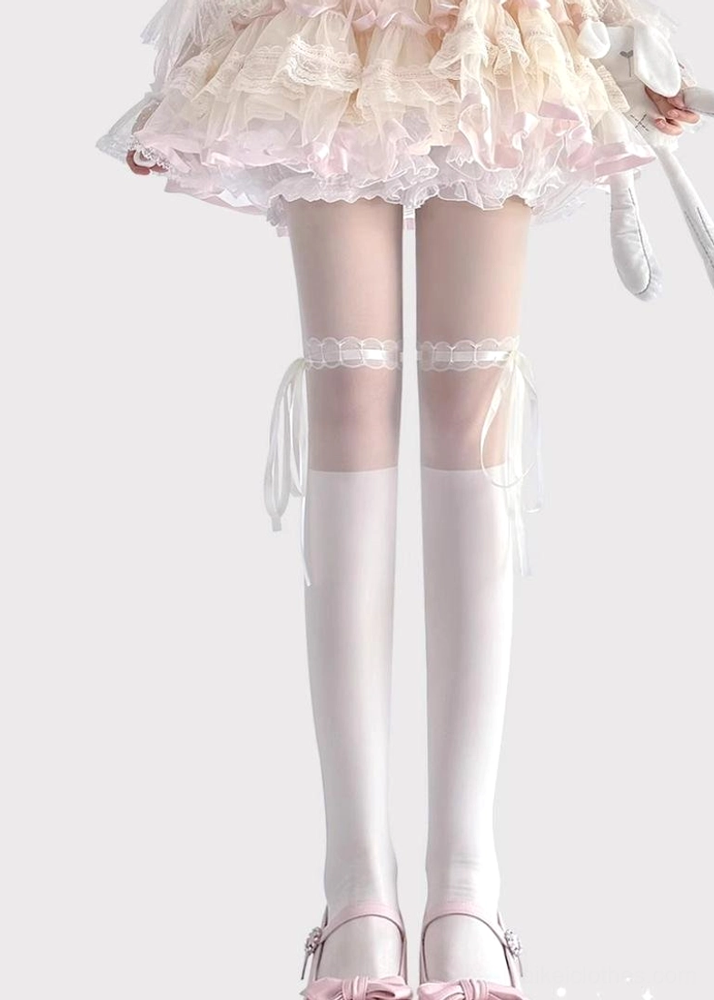 White Jirai Kei thigh-high lace socks with ribbon bow details front view low angle model wearing lolita pink bow shoes