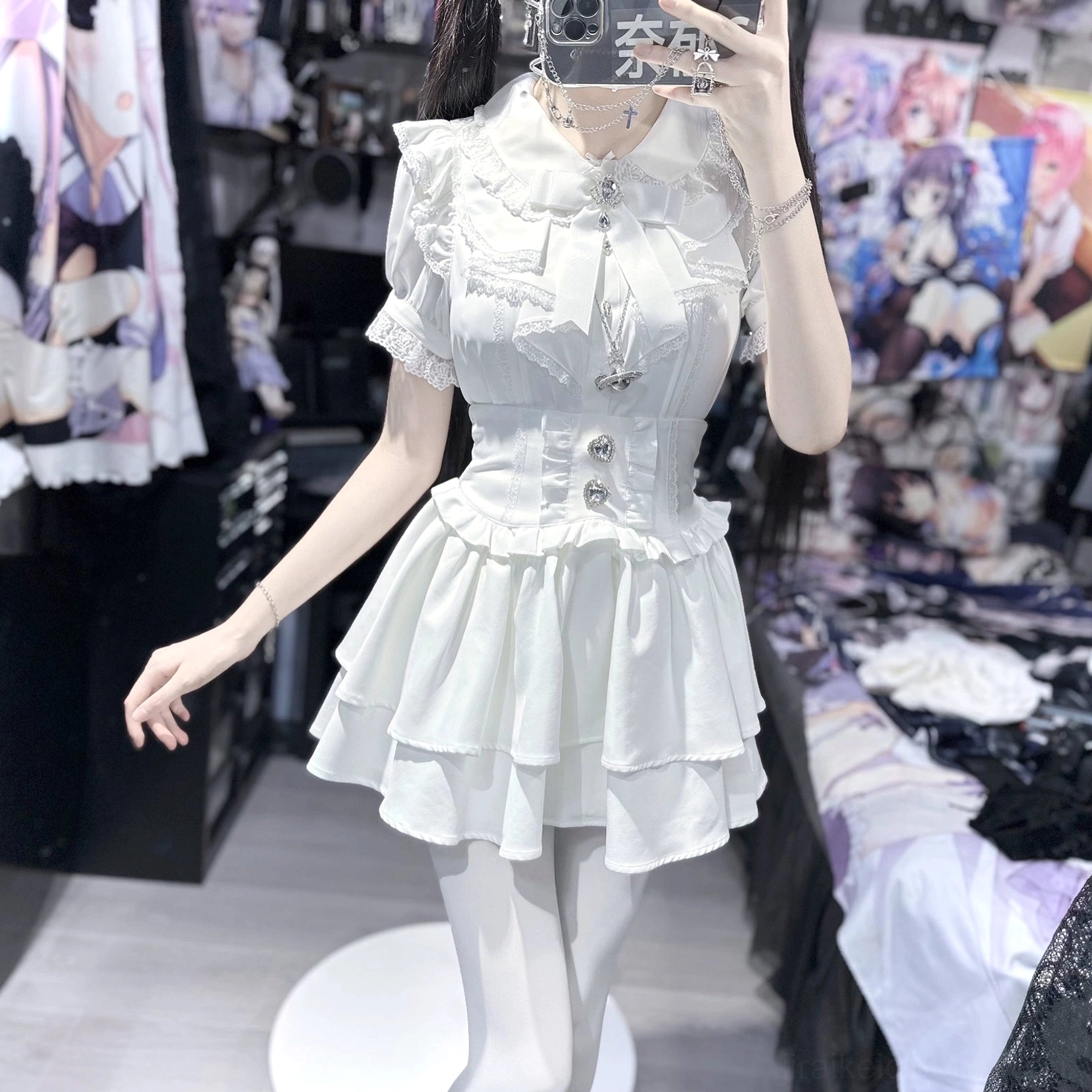 White jirai kei blouse and tiered skirt set side view on mannequin, ruffled puffed sleeves, bow neck trim, double-tiered mini skirt design