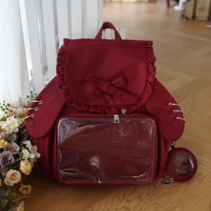 Jirai Kei bunny ear itabag backpack in wine red color with ruffled butterfly bow and transparent display pocket for badges and collectibles, flat lay front view