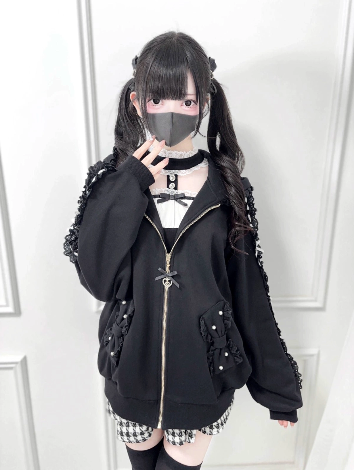 Black Jirai Kei zip-up hoodie full body styling, displaying oversized loose fit, pearl-adorned pockets, cutout shoulder details, paired with checkered mini skirt
