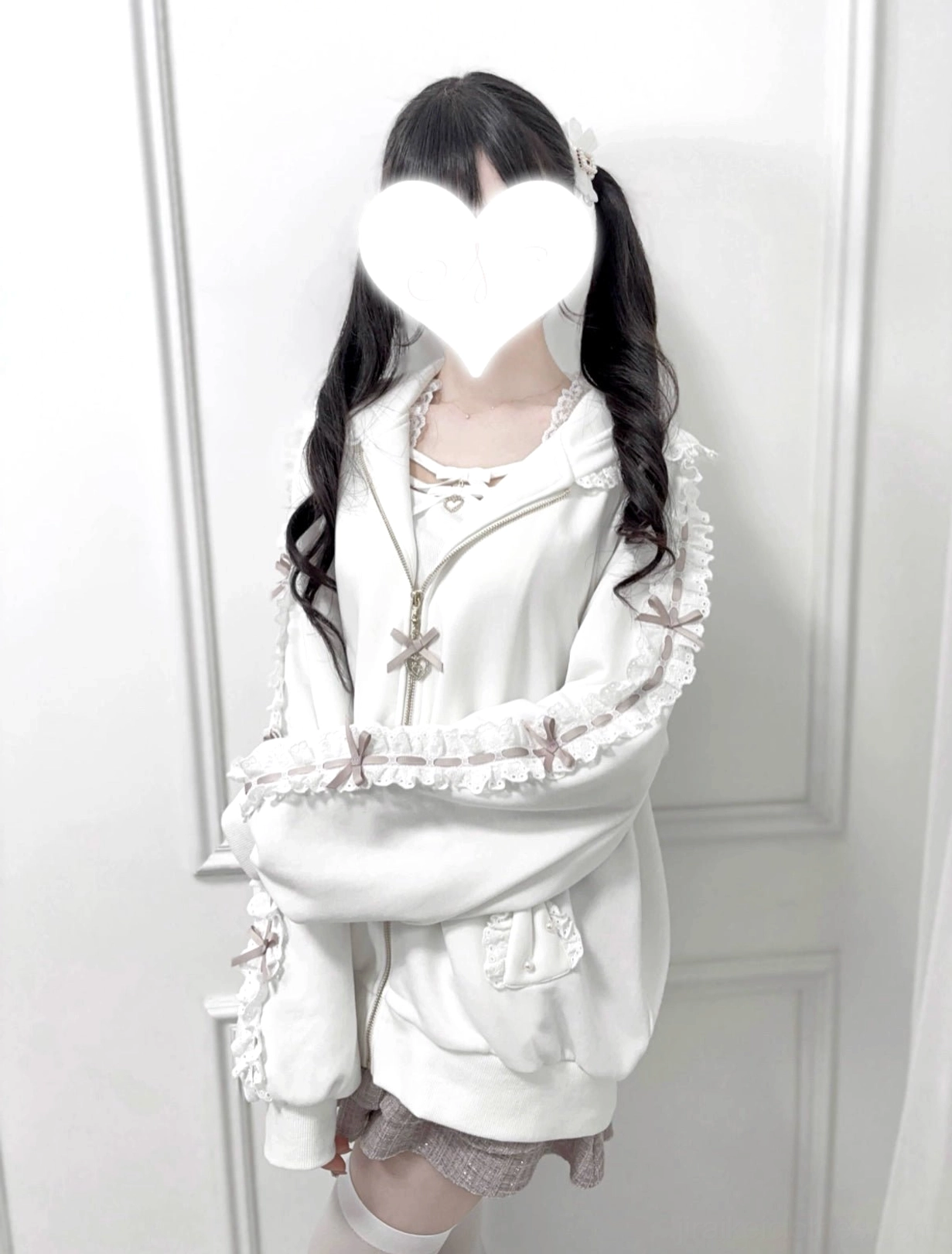 White Jirai Kei zip-up hoodie upper body detail shot, showcasing lace ruffle sleeve construction, oversized fit, bow zipper pull, and heart face cover styling