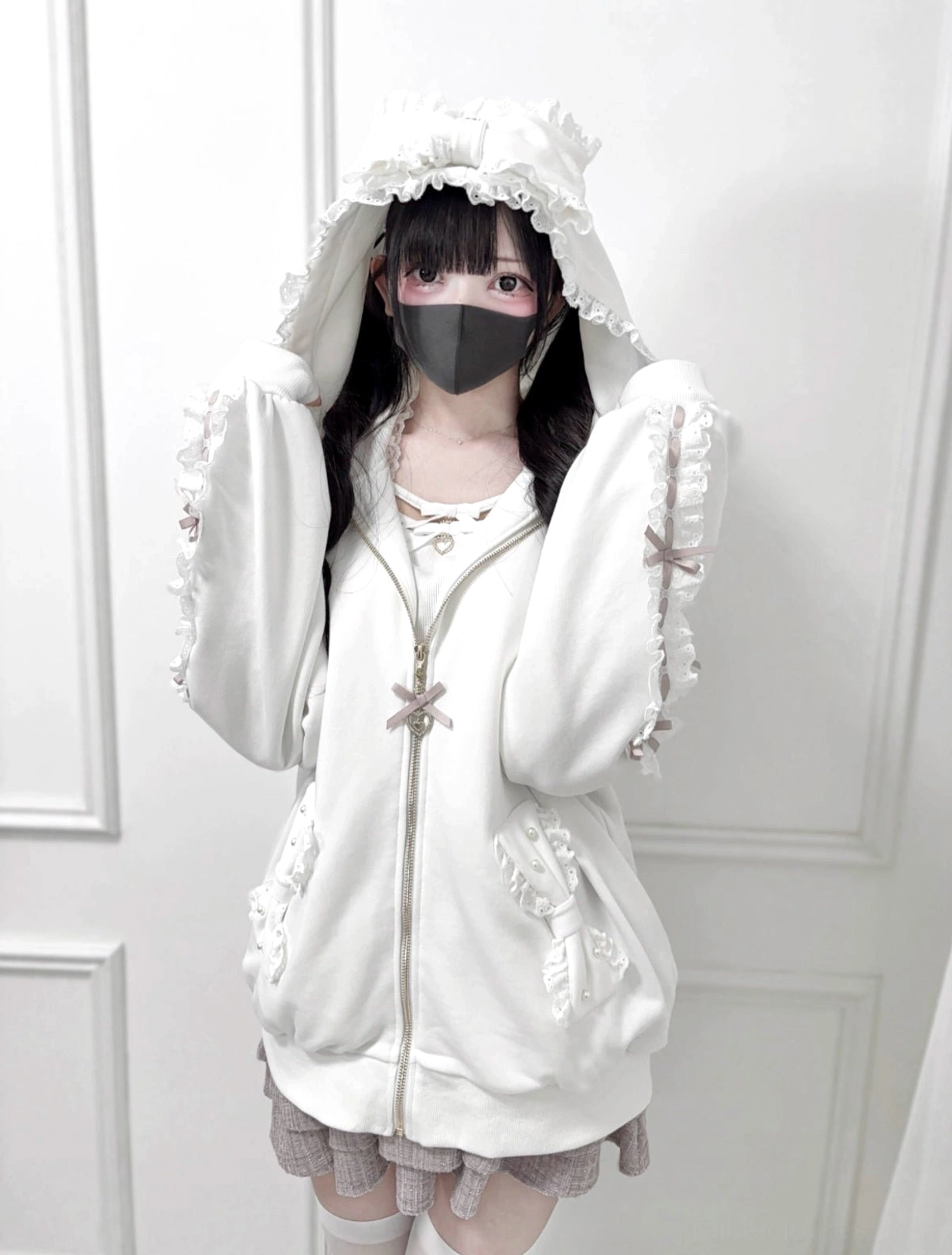 White Jirai Kei zip-up hoodie front upper body portrait, featuring frilled ruffle hood, lace bow sleeve trim details, and bow-adorned zipper pull accent