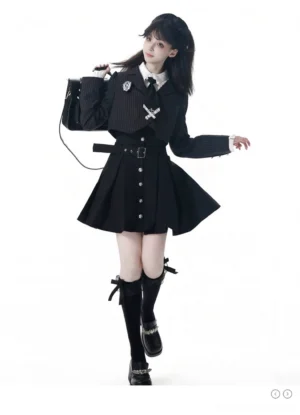 Dark academia JK school uniform front three-quarter angle showing belted cropped pinstripe blazer, fitted blouse with V-shaped chest ruffles, pleated dress skirt, and shoulder bag on female model studio background