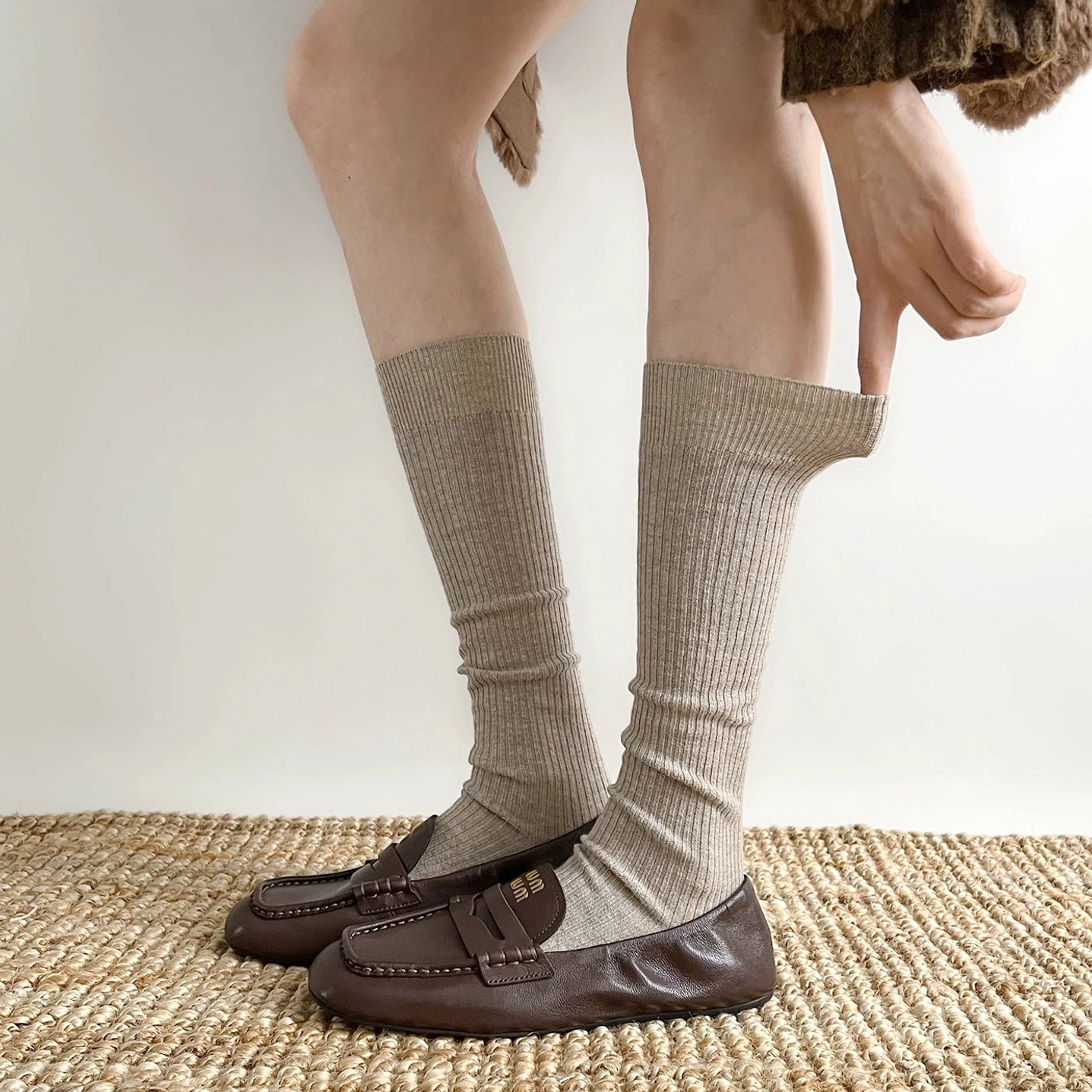 Light khaki calf-length ribbed socks worn with loafers cropped fuzzy coat Japanese style side angle
