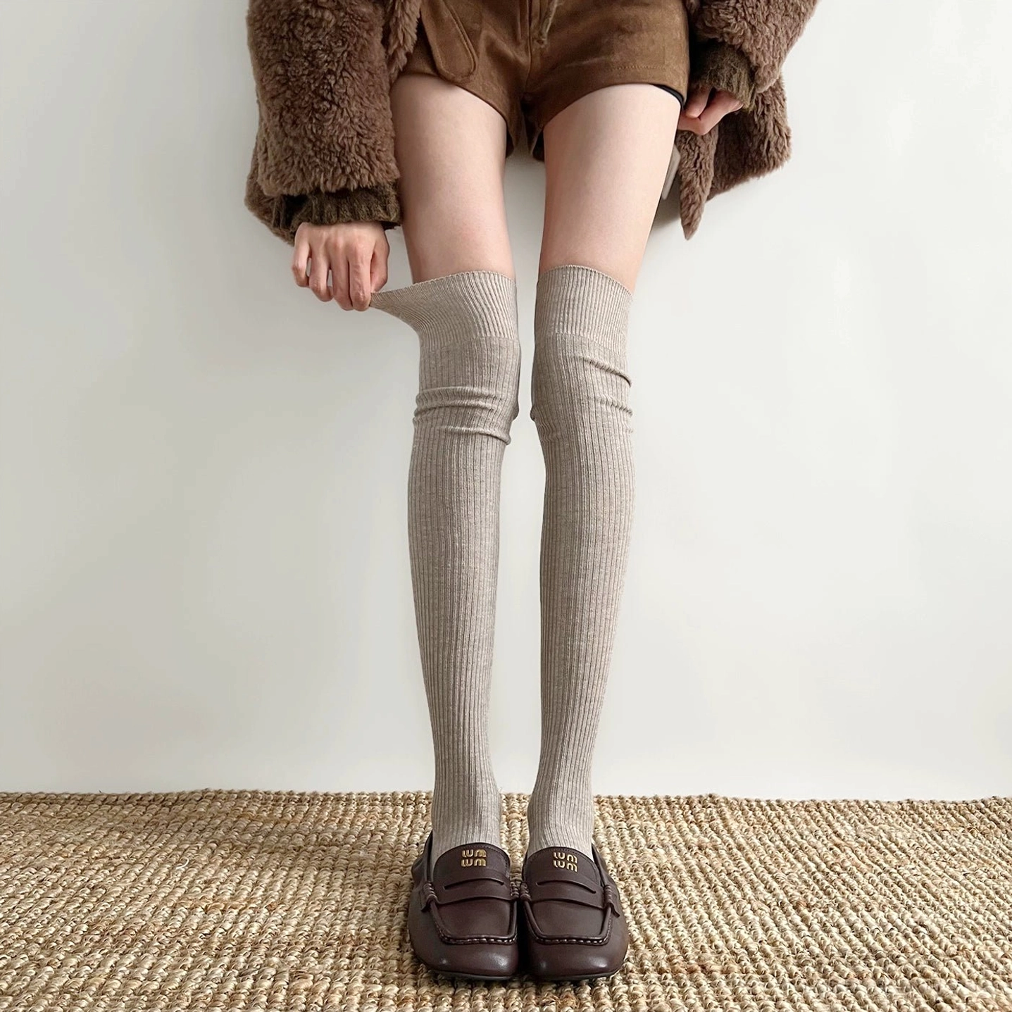 Light khaki over-the-knee ribbed socks Jirai Kei worn with loafers fuzzy coat woven rug background