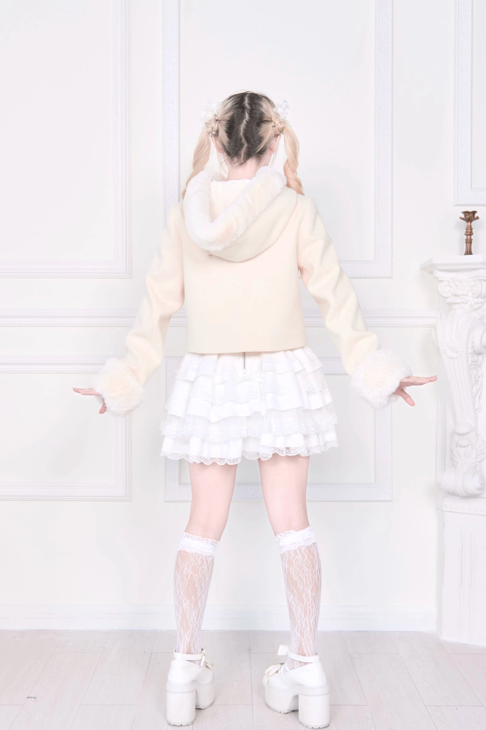 Light apricot hooded rousangata coat back full-body model view, light hair model paired with white ruffle skirt and lace socks, rear silhouette of jirai kei cropped coat design
