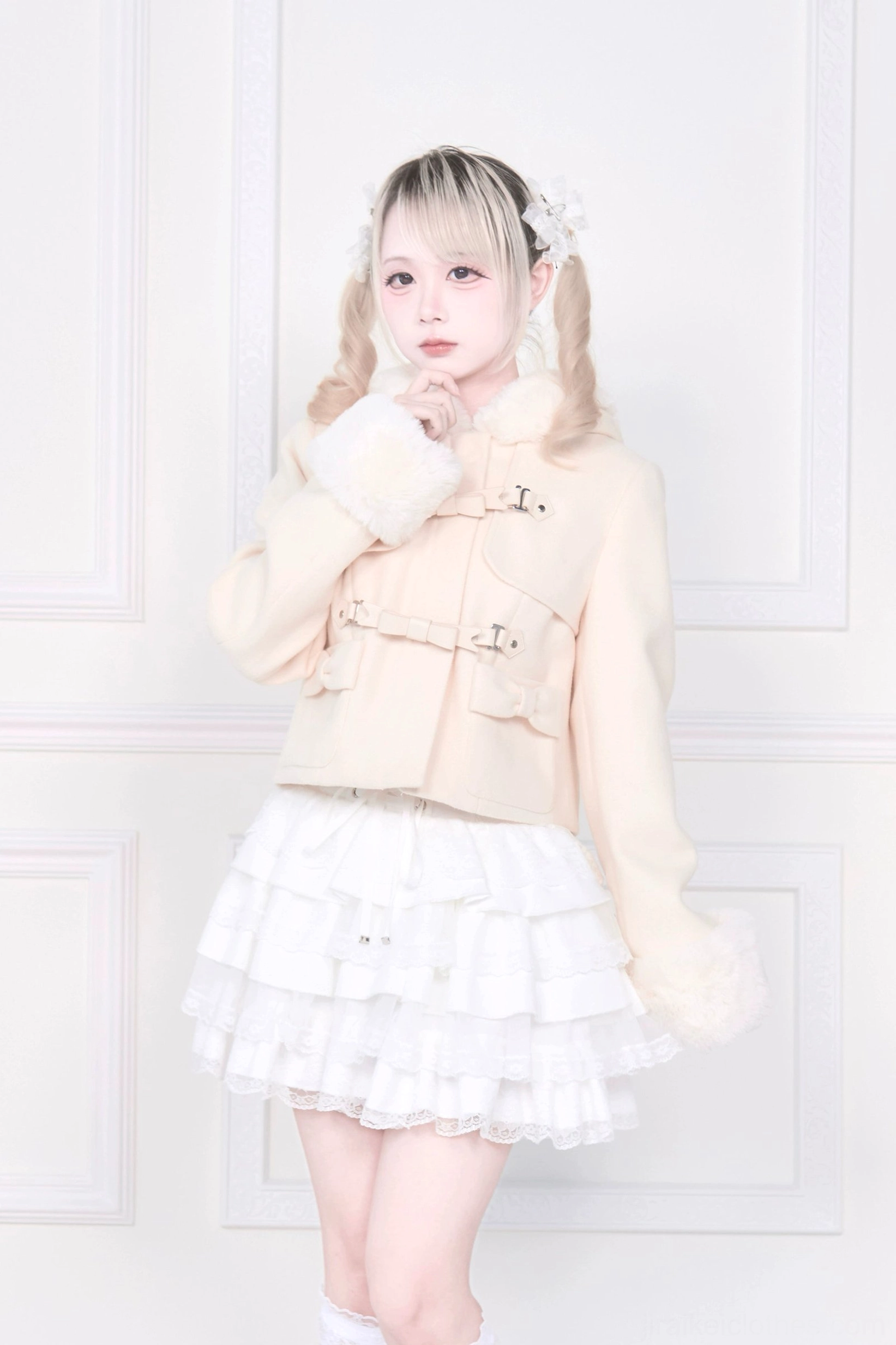 Light apricot beige hooded rousangata cropped coat front three-quarter model shot, blonde twin-tail model wearing fluffy white fur trims and decorative buckles, jirai kei aesthetic