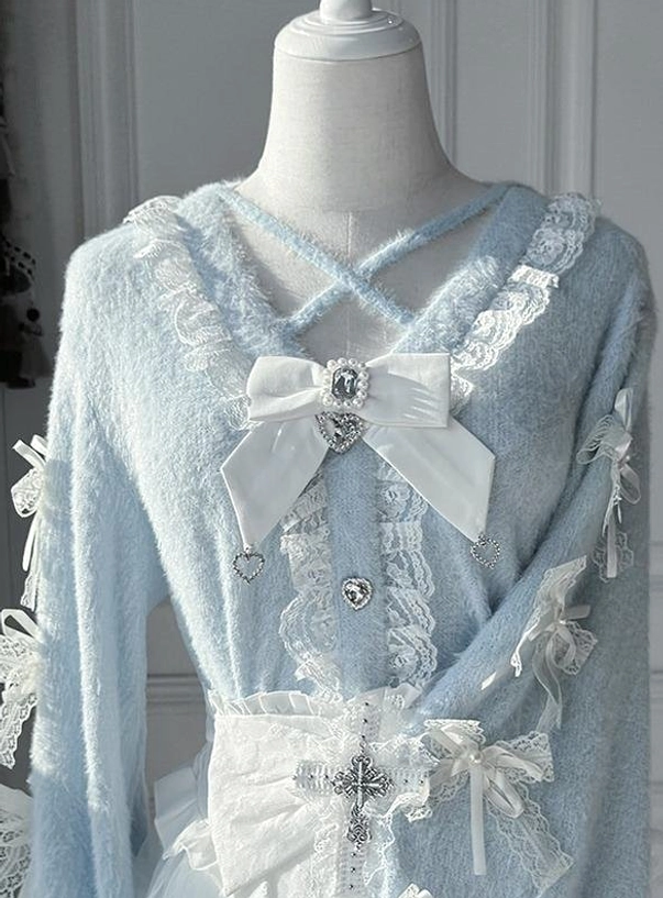 Light blue fuzzy Jirai Kei cardigan close-up with lace trim, white bow and cross charm details on mannequin in vintage setting