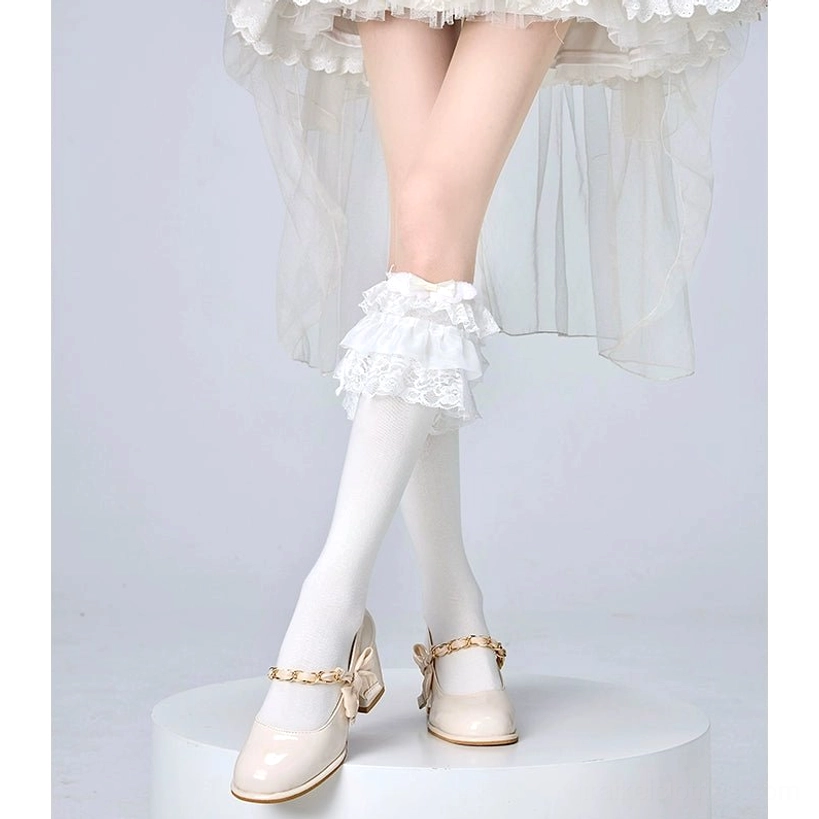 Lolita calf socks with delicate ruffled lace cuff and smooth knit texture worn crossed-leg with white tiered skirt jirai kei fashion