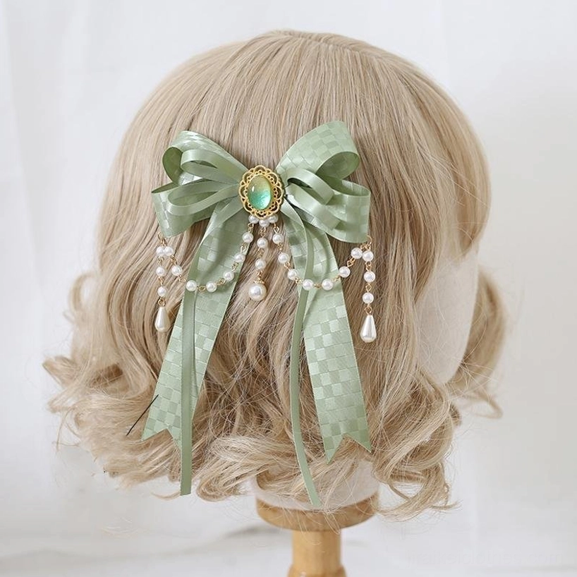 Matcha green gemstone bow hair clip featuring green gem center stone, pearl drop tassels, checkered satin ribbon detailing on blonde wig mannequin back view—romantic Jirai Kei hair accessory