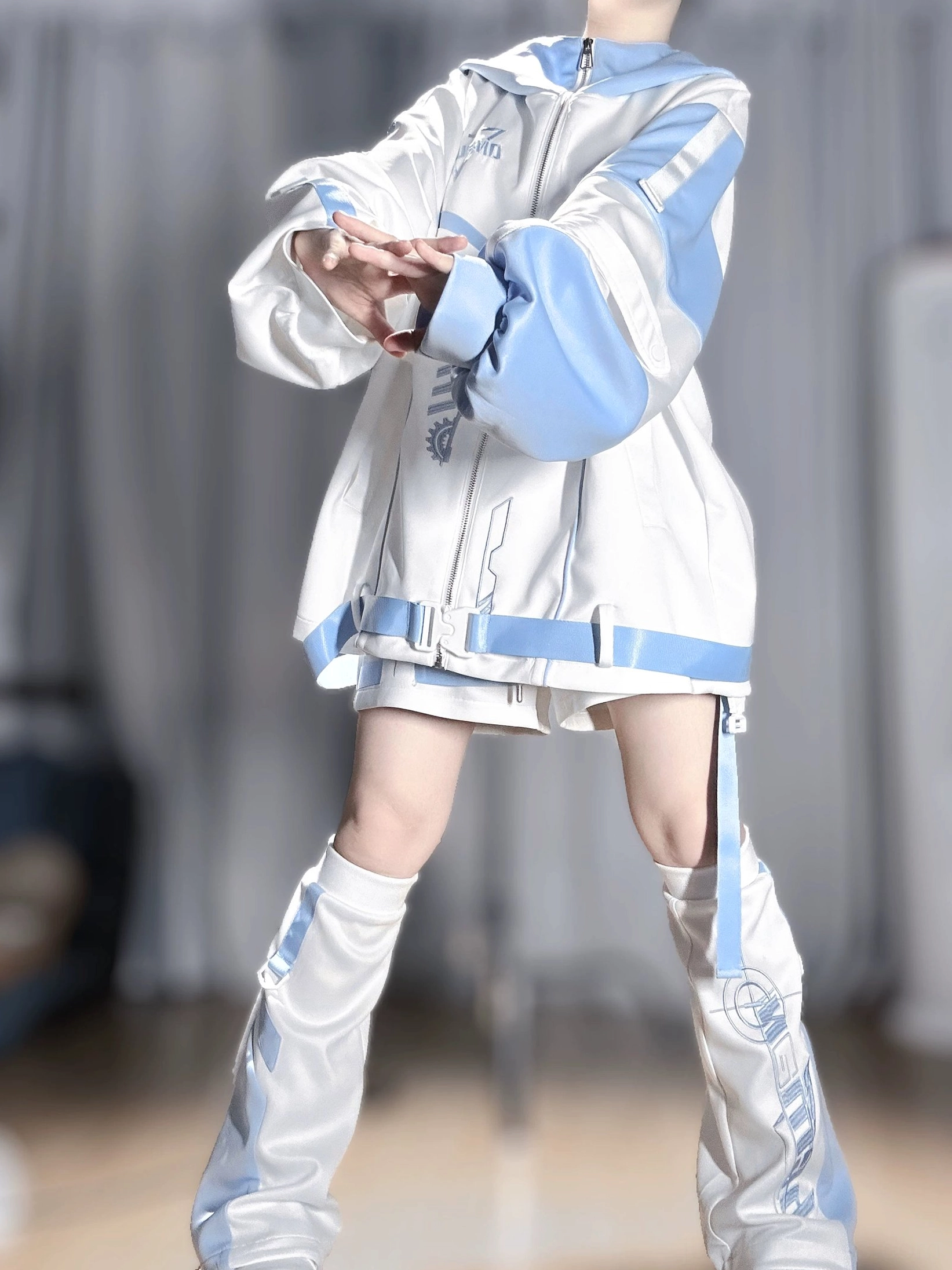 Mizuiro techwear hoodie jacket front three-quarter view with white and blue color block design, elastic shorts, and leg warmers complete set on faceless model indoors