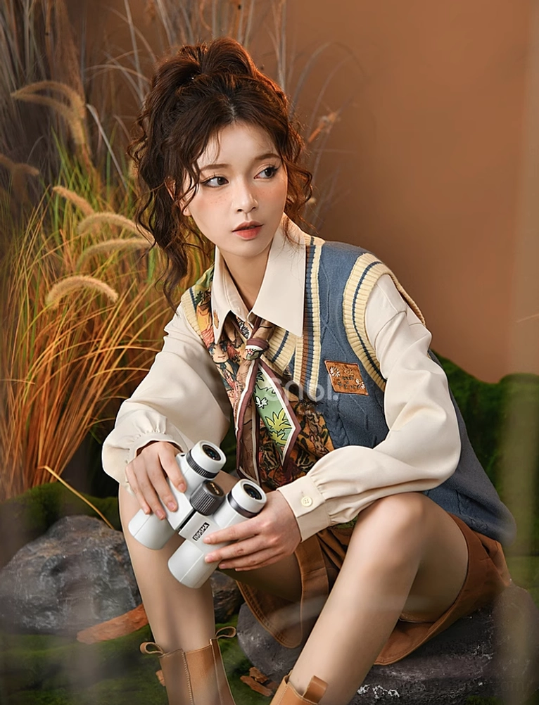 Close-up detail of brown mori kei shorts showing embroidered waistband, button-zip closure, and functional side pocket