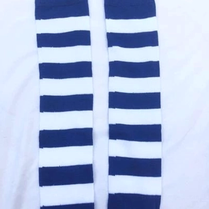 Navy blue and white striped over-the-knee socks flat lay top-down view, uniform horizontal stripe pattern, white fabric background