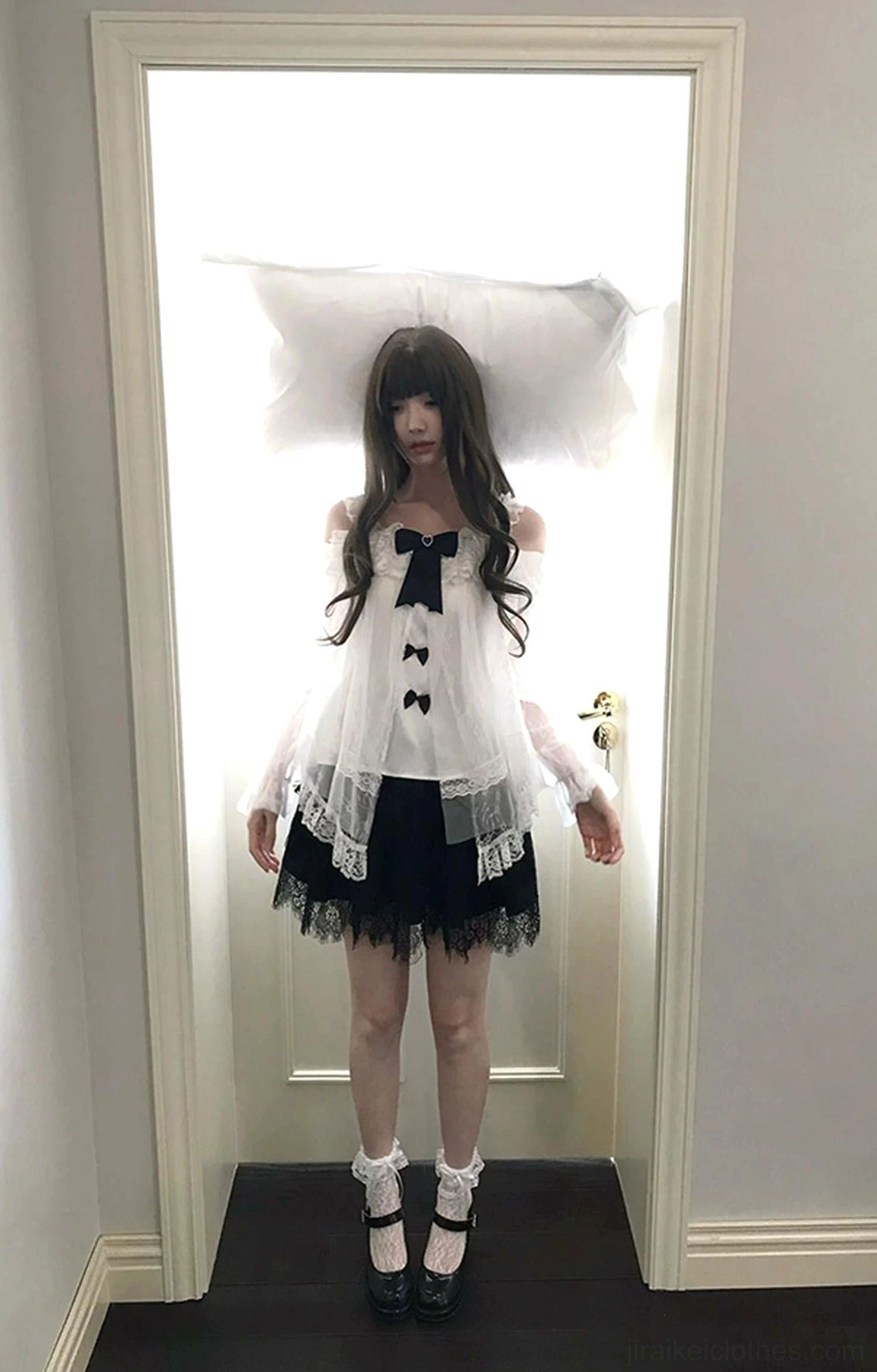 Half-body side-front angle of off-shoulder sheer lace blouse displaying ruffled cuffs, black satin bow decorations, delicate tulle layering, and intricate lace trim embellishments