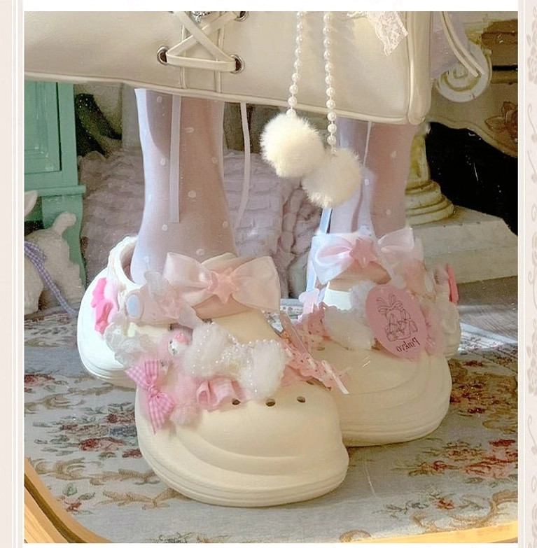 Off-white Jirai Kei decorative clog sandal with pink bows, lace trim, fabric flower charm, cute tag detail, worn with polka-dot pom-pom socks back angle