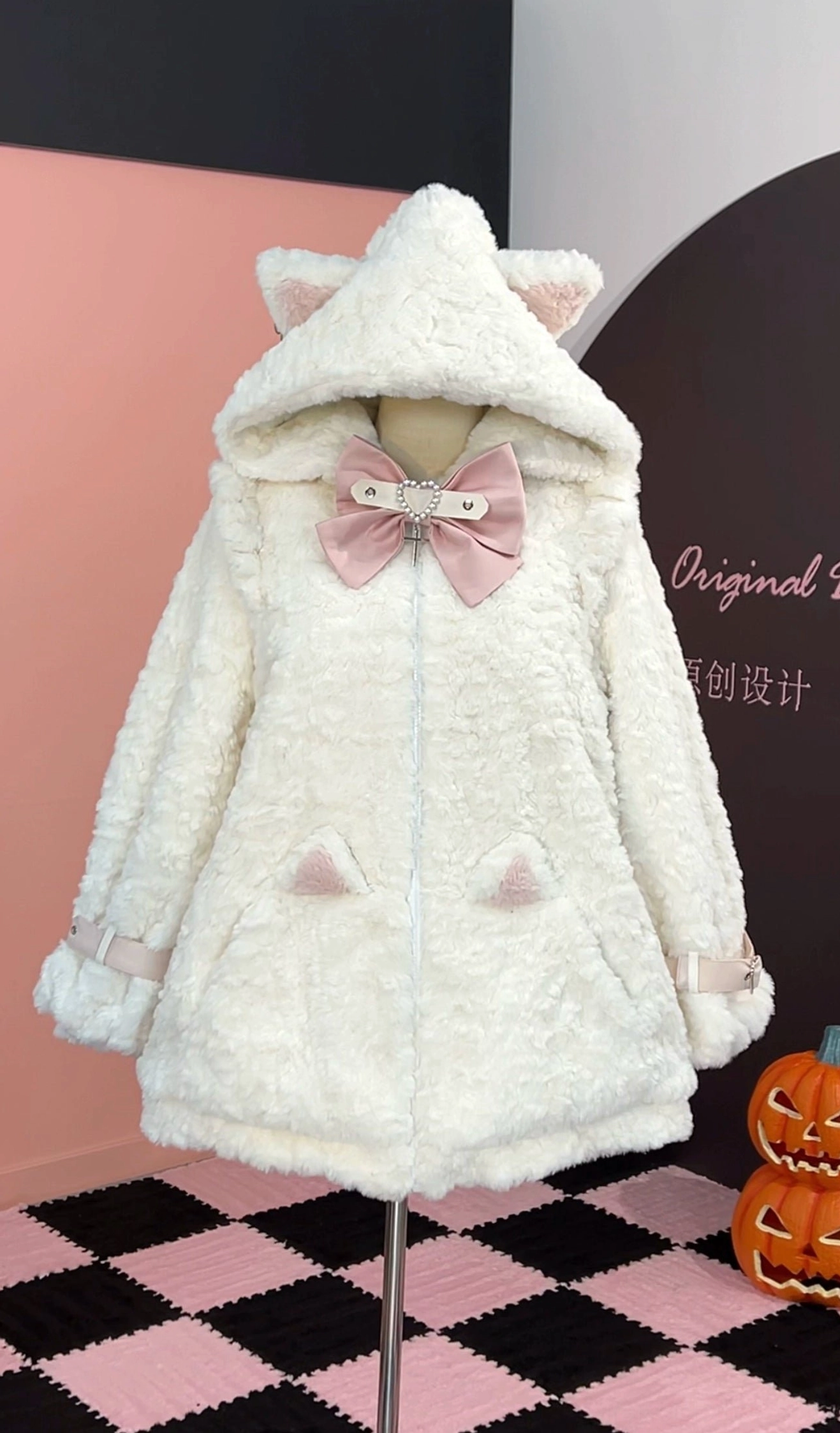 Off-white and pink Jirai Kei fleece coat with cat ear hood, pink bow decoration, pink hood ears, and cat ear pocket accents, front view on mannequin