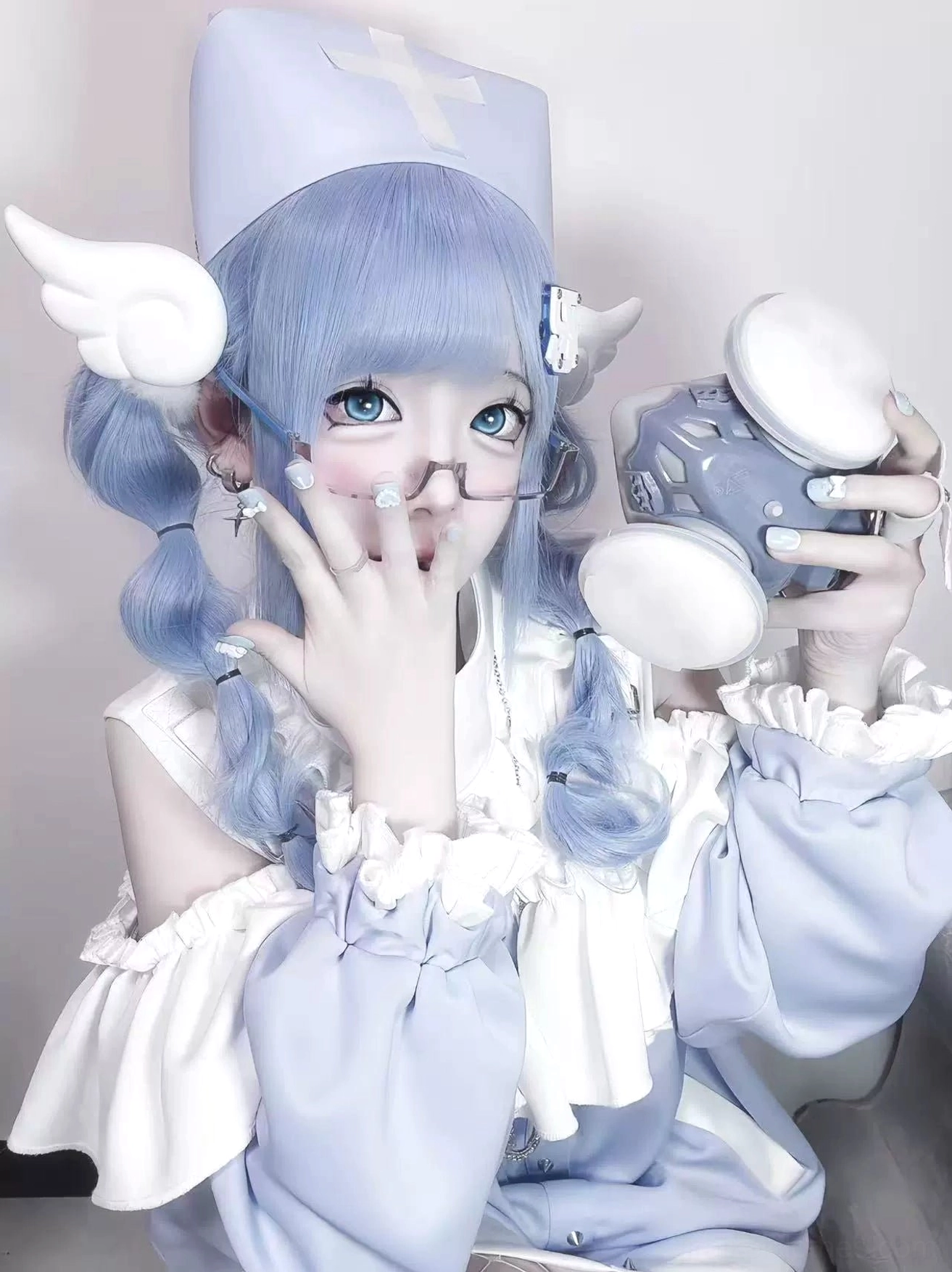 Close-up frontal portrait of open-shoulder Tenshi Kaiwai sweatshirt with ruffled sleeves and round toy camera prop