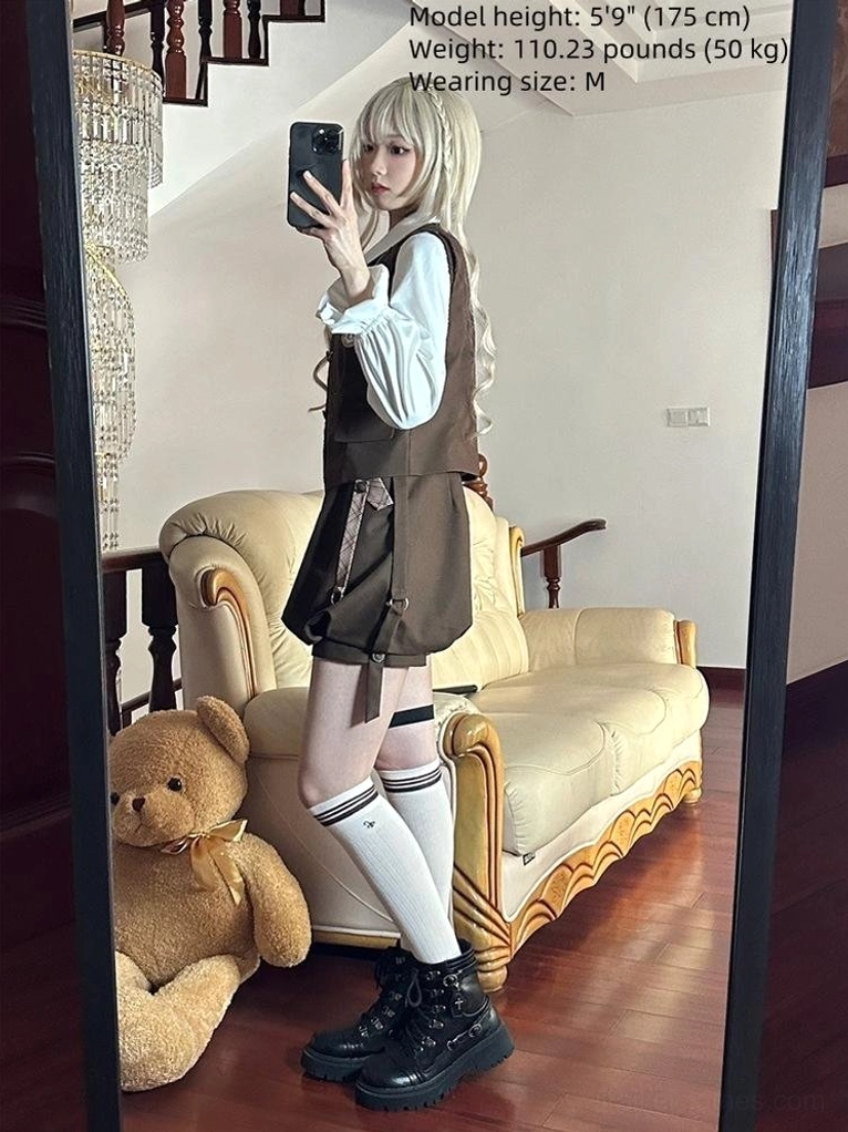 Side-view mirror selfie of Detective Ouji Lolita outfit on blonde model in vintage living room, showing fitted brown suspender shorts, ruffled sleeve blouse structure, and complete ensemble tailoring