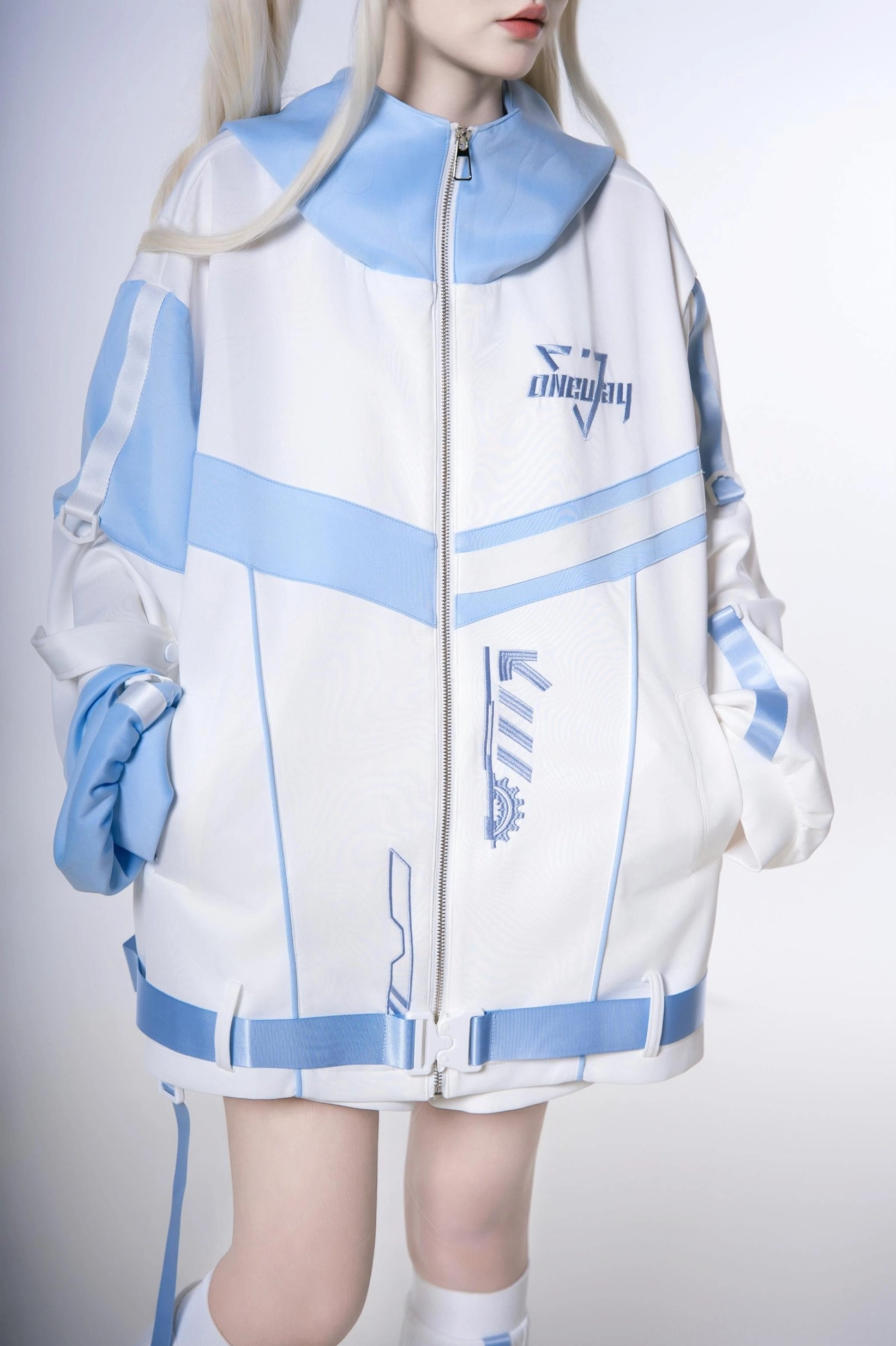 Close-up flat shot of oversized techwear hoodie front detail - showing zipper closure pocket construction and color blocking in white and blue
