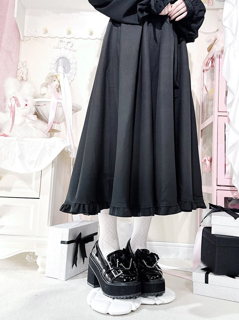 Top-down overhead view of paired black patent leather Jirai Kei platform shoes on white display base, showing glossy leather, rhinestone decoration straps, square platform heel design, white socks, and black long ruffled skirt