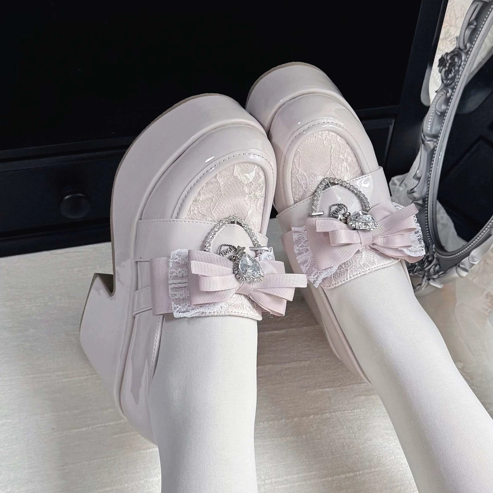 Pastel pink Ryousangata Jirai Kei platform loafers with mesh lace panel and pink satin crystal bow, side profile on-foot view with white sheer tights
