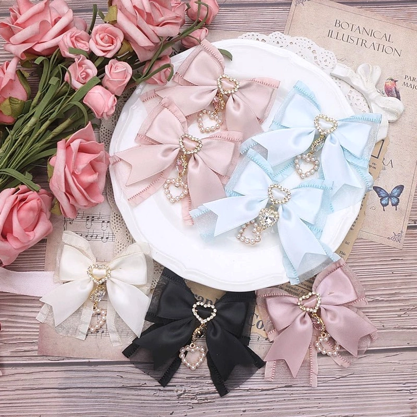 Close-up detail of pearl bow hair clip construction showing rhinestone placement and ribbon mesh layering technique