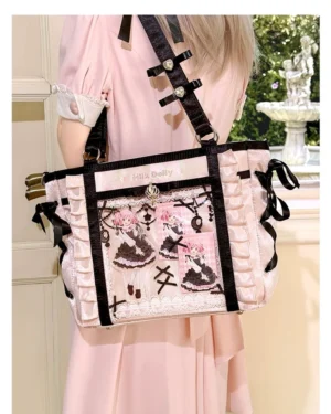 Pink and black jirai kei ita tote bag rear view showing black ribbon bows and black frame trim with clear window anime doll prints, outdoor garden scene with model in pink lolita dress