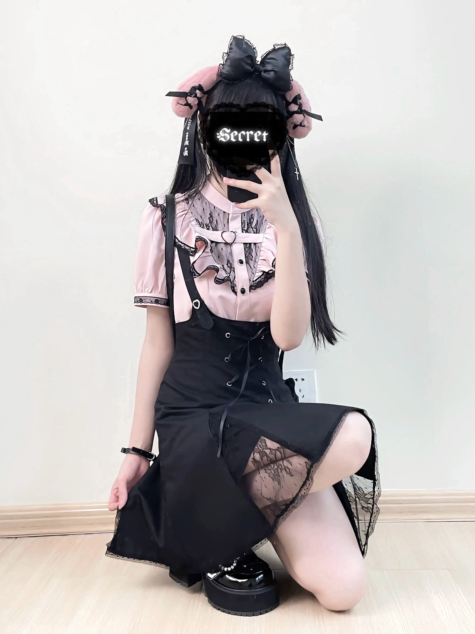 Pink and black jirai kei two-piece set kneeling front view lace-trimmed blouse lace-up front skirt split hem detail