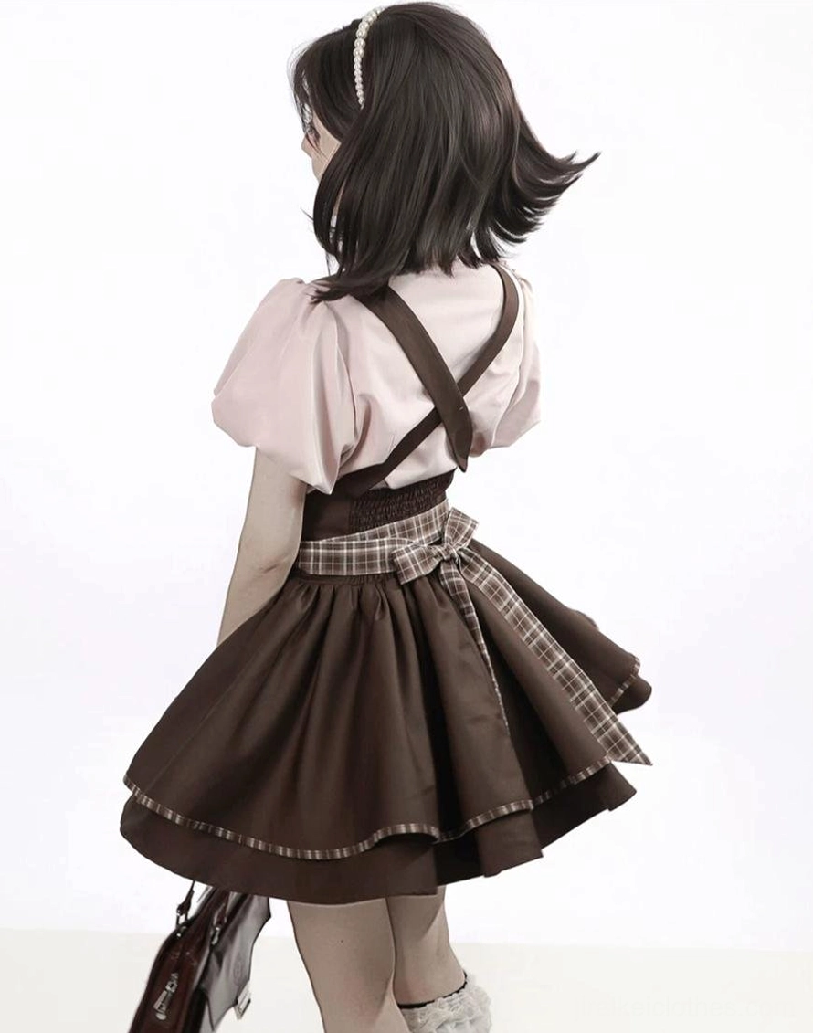 Jirai Kei suspender skirt outfit back view showing pink bubble sleeve blouse plaid waist belt brown layered skirt with cross-back straps