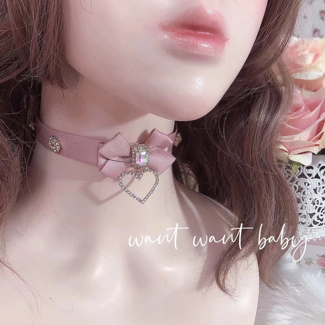 Pink satin ribbon bow rhinestone choker necklace on BJD doll half-face portrait showing delicate central rhinestone and heart pendant from close-up angle