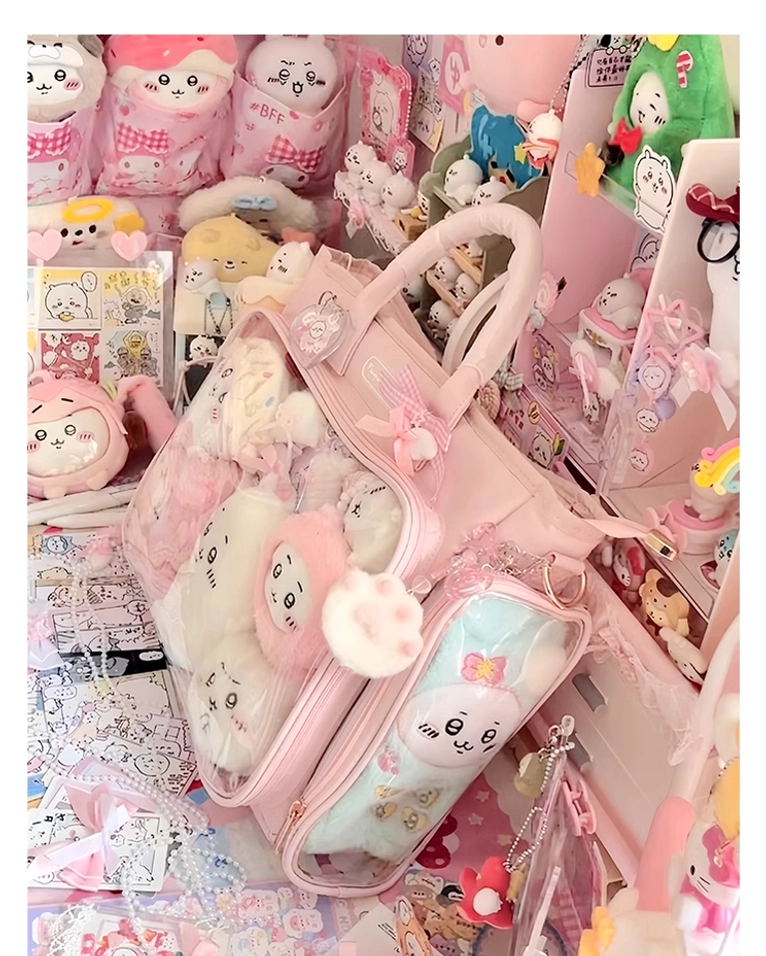 Pink itabag side overhead view in cute goods display area with plush toys inside, cat-shaped bag charm, surrounded by stationery and collectibles