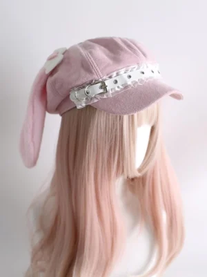 Pink Jirai Kei beret with detachable bunny ears front side view showing angel wings heart decorations white leather buckle on mannequin with light pink wig