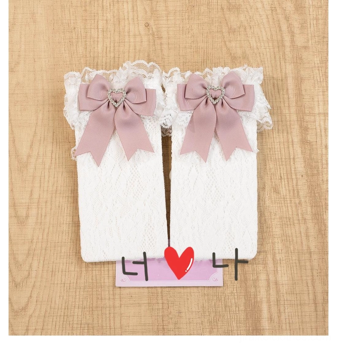 Pink jirai kei lace socks with heart-shaped rhinestones and decorative satin bows displayed in romantic aesthetic styling