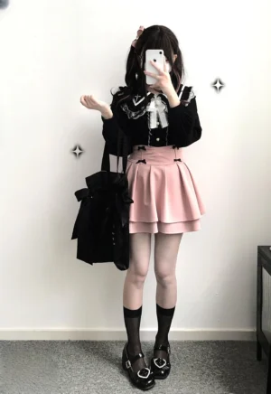 Female model in sweet Lolita style wearing pink high-waist puff Jirai skirt with black blouse and white bow tie details side mirror view