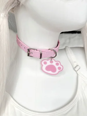 Pink leather cat paw charm choker with silver hardware, side view on mannequin featuring blonde twin tails and white camisole, Jirai Kei style necklace pendant