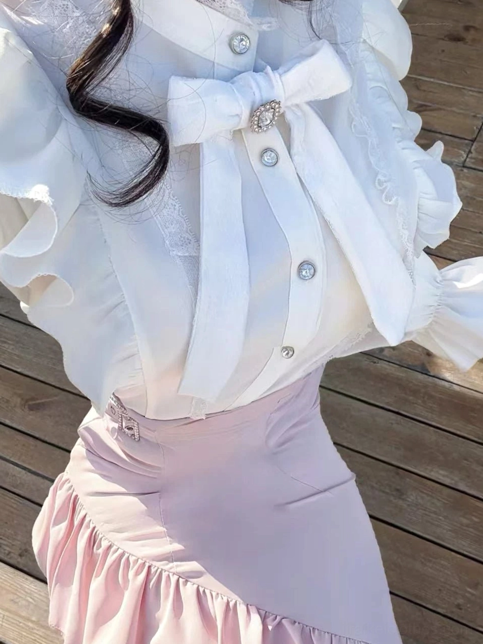 Front close-up of waist area showing crystalline brooch on decorative bow tie and metal waist buckle on pink fishtail skirt - Jirai Kei aesthetic embellishment details