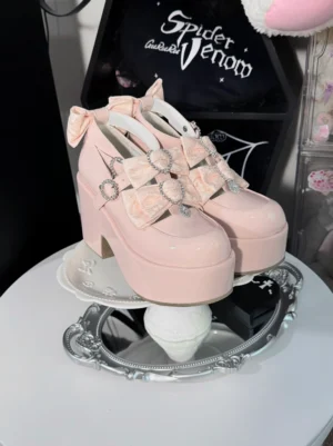 Pink patent leather Jirai Kei chunky platform heels with heart rhinestone ankle straps displayed on mirror tray from overhead angle