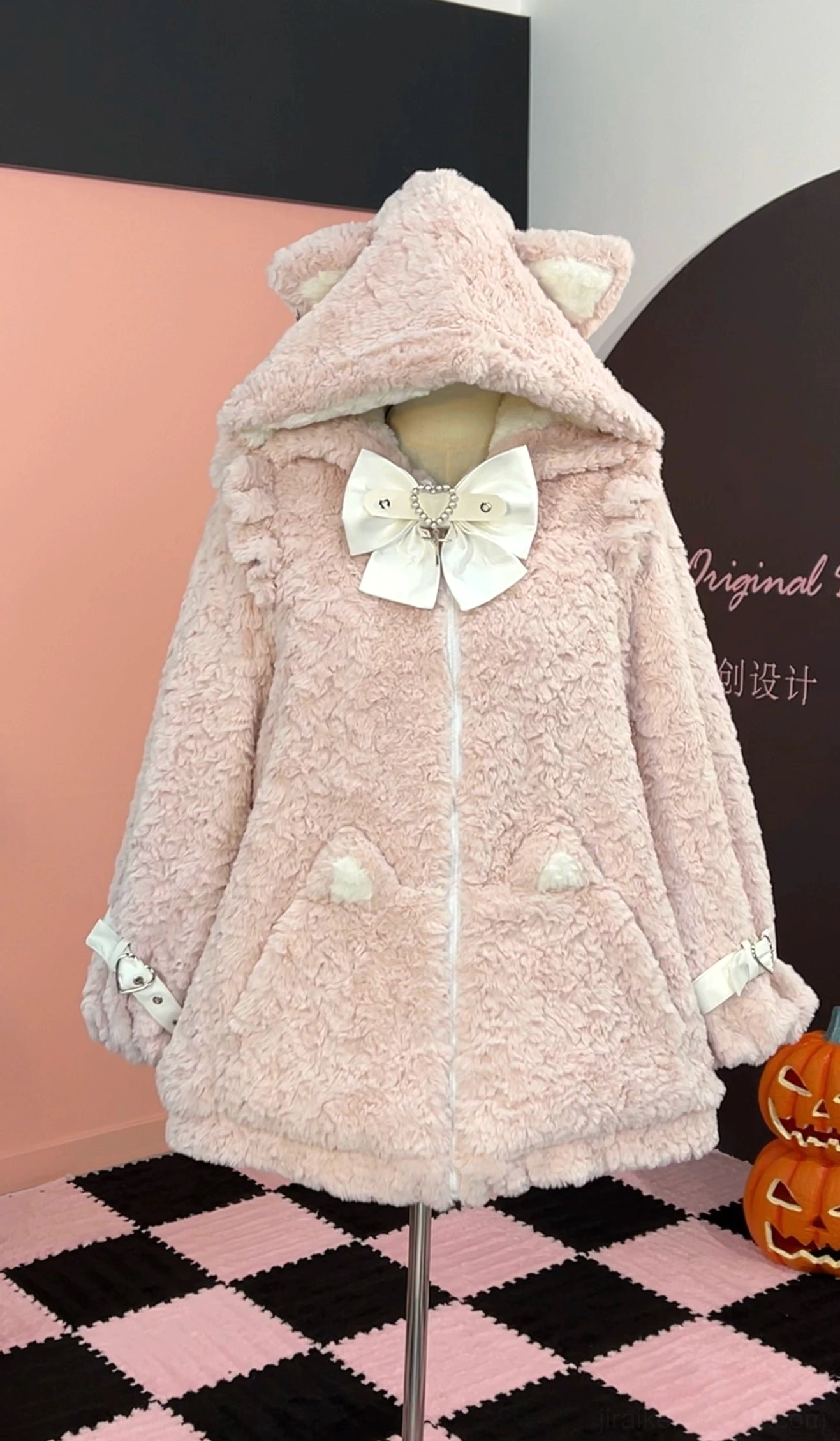 Pink and white Jirai Kei fleece coat with white cat ear hood, white bow decoration, white buckle cuff details, and pink hood ears, three-quarter view
