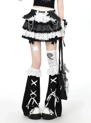 Black and white polka dot Jirai Kei tiered ruffle mini skirt with matching ruffled leg warmers, front lower body view showcasing chain decorations and stripe trim details