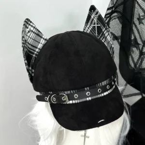 Punk ear baseball cap left side view showing black-white plaid ears and studded leather strap, dark suede base fabric