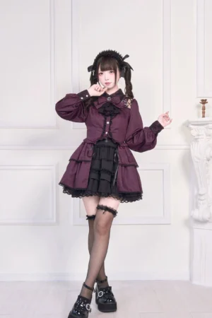 Purple Jirai Kei blouse with detachable collar bow, lace cutout shoulders, three-quarter front angle showing ruffled cuffs and tiered hem detail