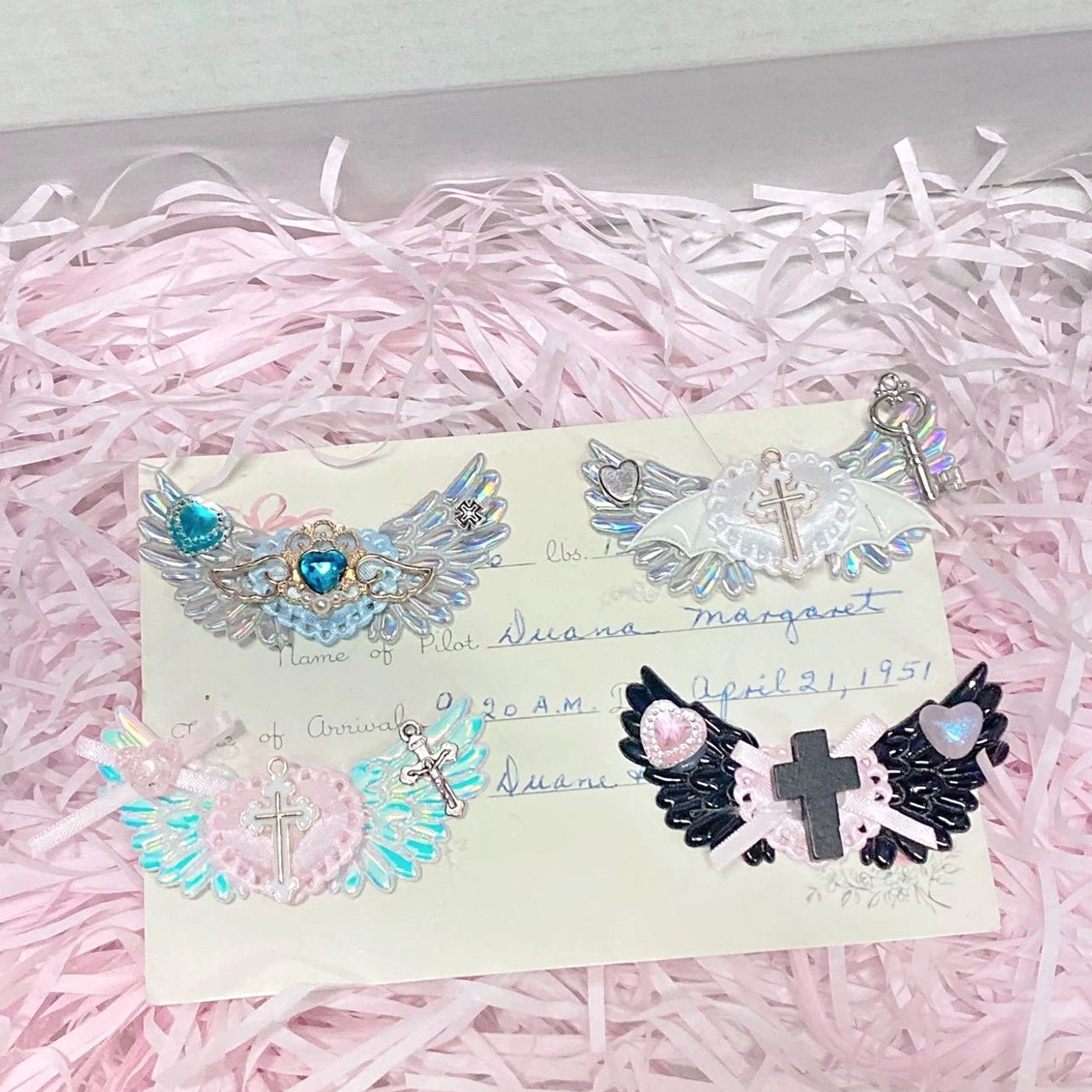 Random colorful wing hair clip selection in jirai kei style with surprise element iridescent wings and gothic symbol combination