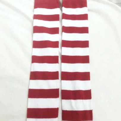 Red and white striped over-the-knee socks worn styling, street fashion alternative look, punk aesthetic outfit pairing