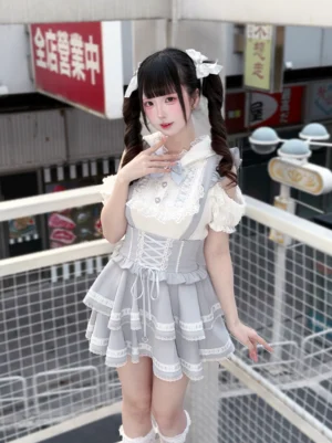 Ryousangata bunny ear hooded blouse and tiered suspender skirt set front view on female model with twin tails in outdoor urban rooftop setting white-gray color scheme cold-shoulder design