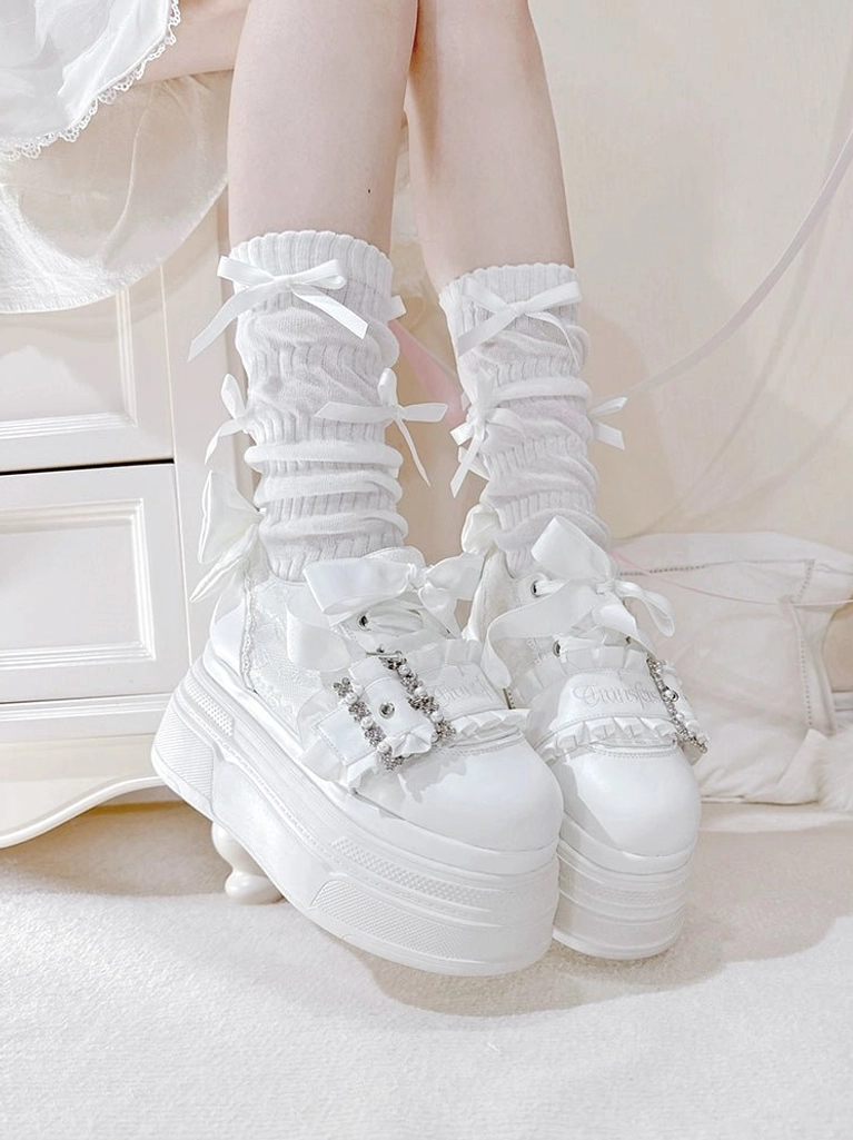 White Ryousangata platform shoes side rear view on feet with ruffled ribbon socks, displaying rhinestone strap decor and thick platform sole