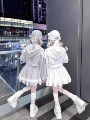 Rear view of two models in matching lace-trimmed ryousangata hoodies and skirts, cropped hoodie style with ruffled hem details