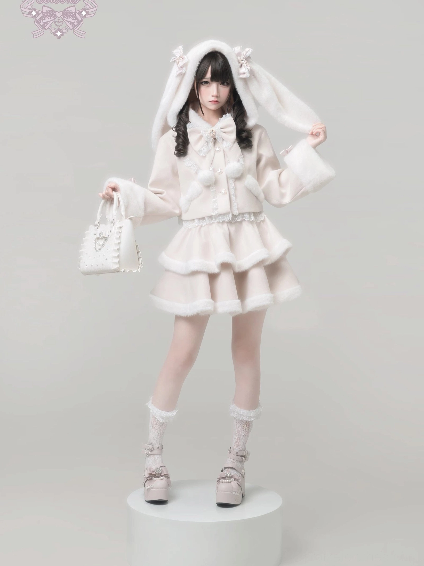 Ryousangata lolita coat set with handheld tote bag, layered ruffle skirt with lace trim, bell sleeves and fur cuffs, Jirai Kei aesthetic standing pose on display