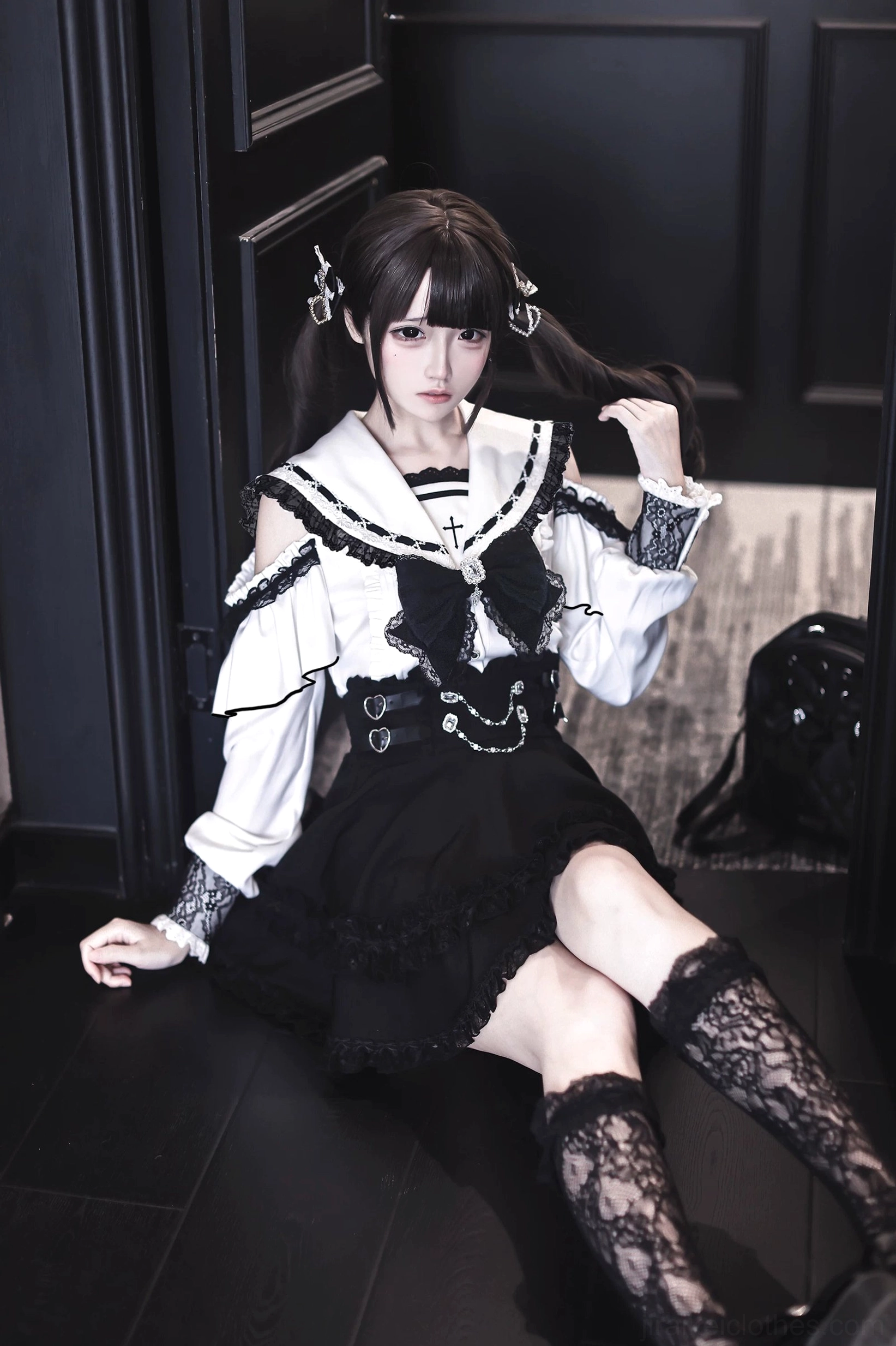 Low-angle sitting view of Jirai Kei sailor collar two-piece set displaying full thigh-high lace socks and ruffled skirt hem detail