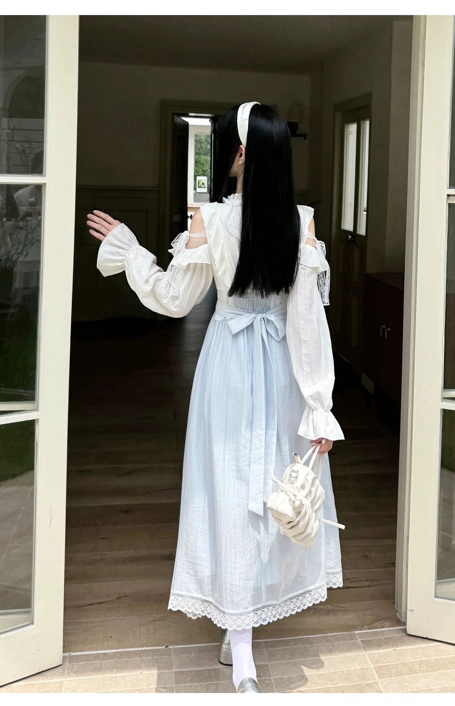 Seiso Kei long midi dress back full view with back waist bow, lace hem, and long sheer sleeves at glass door entrance